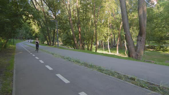 Blond Slender Strong Woman Caucasian Lady Runner Athlete in Black Tracksuit Runs Marathon Speed alt