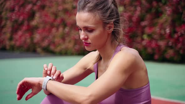 Sportswoman is Checking Data in Activity Tracker After Workout on Open Sport Area alt