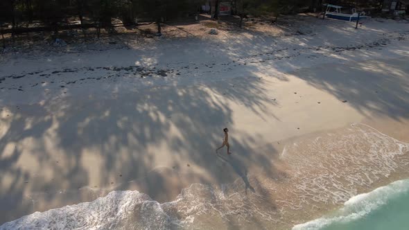 Happy woman enjoying beautiful life,alone on paradise island in Indonesia during summer.Aerial circl alt