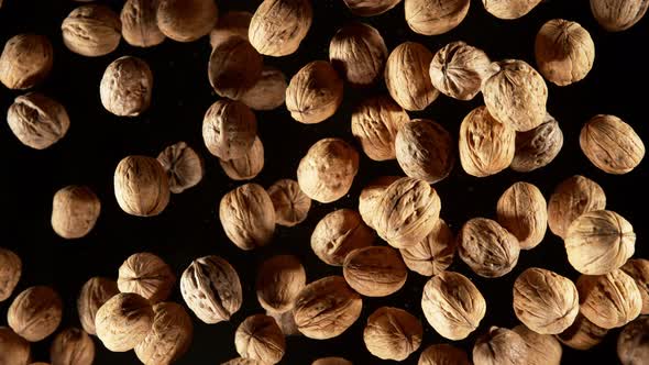 Super Slow Motion Shot of Flying Whole Walnuts Towards Camera Isolated on Black at 1000Fps alt