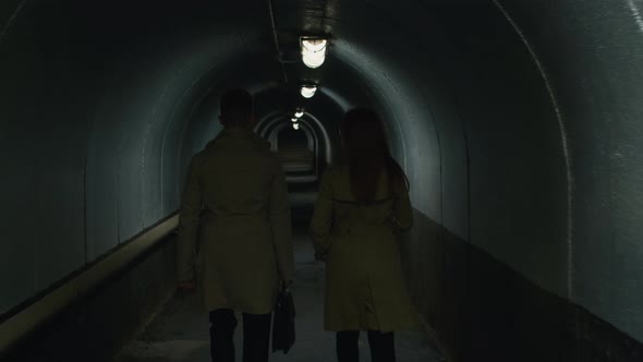 Businessman and woman going through the tunnel alt