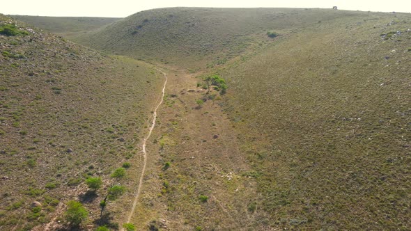 Aerial View of Drone Flying Through Hills