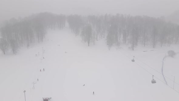 Aerial view of the ski resort with snowy mountain slopes and winter trees.  alt