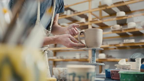 Close Up of Professional Potter Making Handmade Cup at Pottery Studio Attaching Handle Slow Motion alt