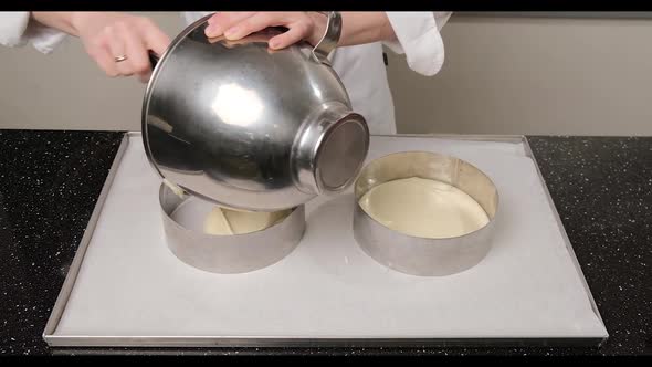 Woman Hands Pouring Cake Batter Into Cake Mold Using a Spatula and Stainless Bowl alt