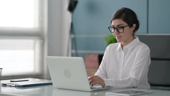 Indian Businesswoman Celebrating Success while using Laptop in Office alt