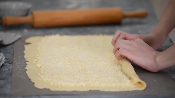 Housewife Making Roll of Dough with Sugar Filling