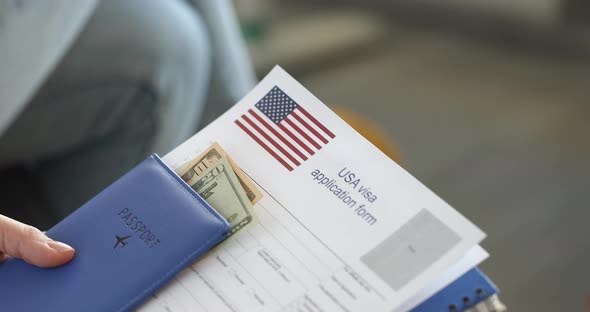 People Sitting in Line with Documents to Obtain American Visa Closeup  Movie Slow Motion alt