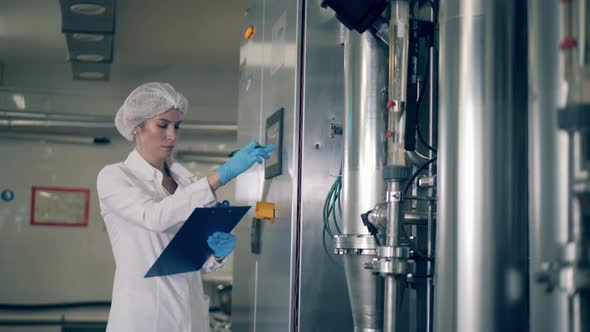 Factory Control Panel Is Being Operated By a Female Expert alt