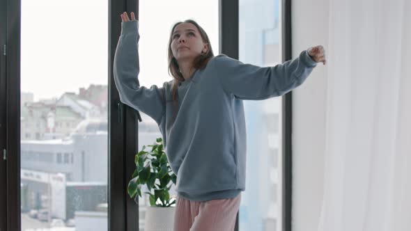 Young Woman in Blue Sweater Feeling the Music in Bright Apartment alt