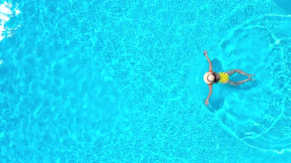 View From the Top As a Woman in Yellow Swimsuit Swims in the Pool by ...