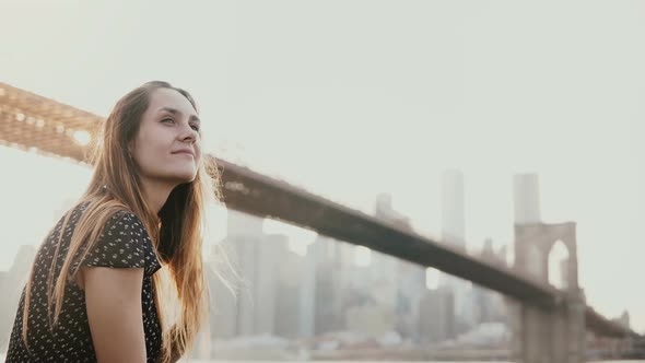 Happy Smiling European Young Woman Smiling, Enjoying Amazing Sunset View of New York Near Brooklyn alt