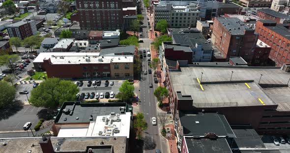 Urban city in USA on sunny day. Aerial tilt up reveal above street traffic. alt