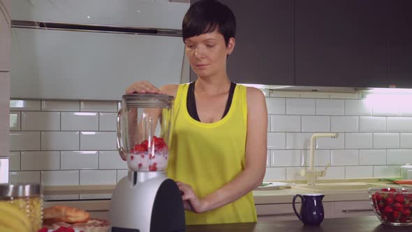 Girl Makes Juice with Berries in Apartment alt