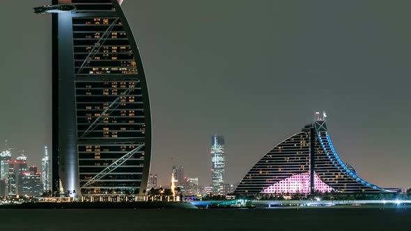 Skyline of Dubai at Night Timelapse with Burj Al Arab in Foreground in Dubai United Arab Emirates alt