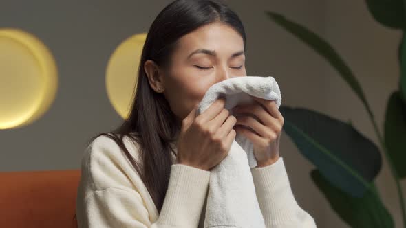 Asian Woman Enjoys a Clean and Smelling Towel After Washing with a New Washing Gel alt