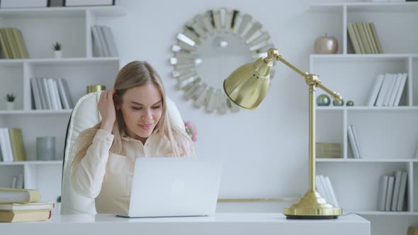 Attractive woman with laptop at the desk indoors alt