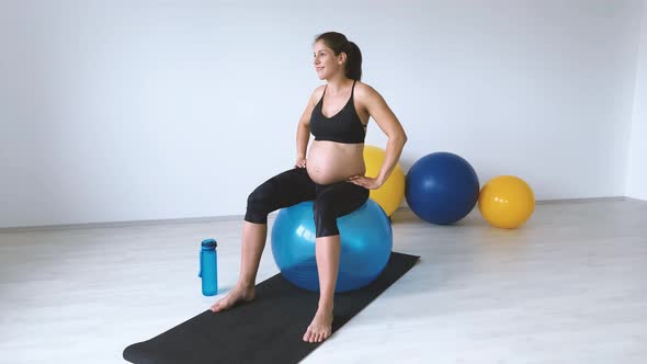 Slow motion shot of pregnant woman during exercise on exercise ball