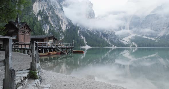 Small Boathouse with Wood Pier and Boats on Braies Lake with Cloudy Weather alt