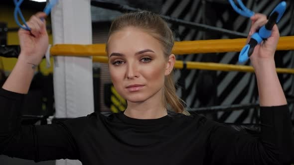 Portrait of a Young Woman with a Skipping Rope in Her Hands in a Boxing Gym alt