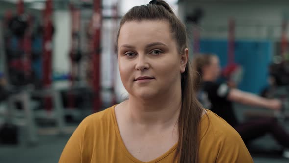 Portrait of smiling caucasian woman with overweight at the gym. Shot with RED helium camera in 4K. alt