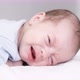 Dissatisfied Crying Upset Sad Newborn Baby Boy Lying in Nursery Cocoon with Blue Clothes on Bed in - VideoHive Item for Sale