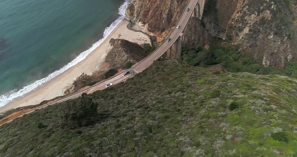 Aerial Drone Stock Video of Bixby Bridge Highway with water and shore below in Big Sur Monterrey Cal alt