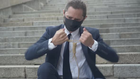 Portrait of Frustrated Businessman in Covid-19 Face Mask Checking Suicidal Rope. Young Depressed alt