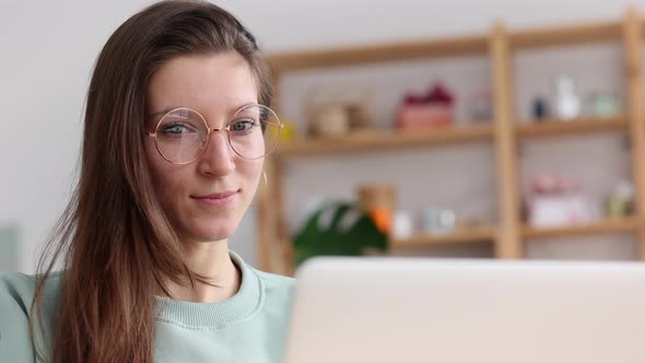 Businesswoman Using Laptop and Laughing While Sitting at Desk in Apartment Interior Spbi alt