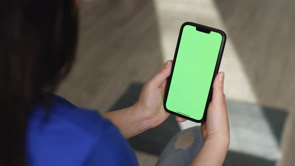 Unrecognizable Woman Hand Holding Smartphone on Green Screen Chroma Key Background alt