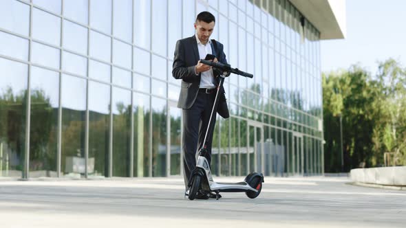 Businessman Rents Electric Scooter Using Mobile Phone App