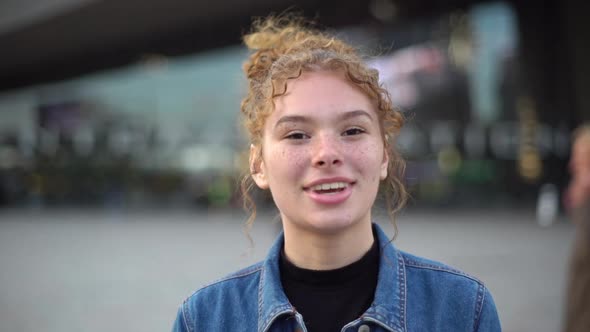 Slowmotion Attractive Coquettish Ginger Girl Having Freckles Curly Hair Wearing Bun Standing alt