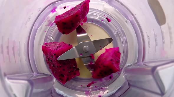 Slow motion of red dragon fruit into the Juice blender. Top view