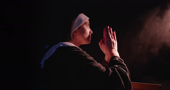 Nun Praying In Dim Light