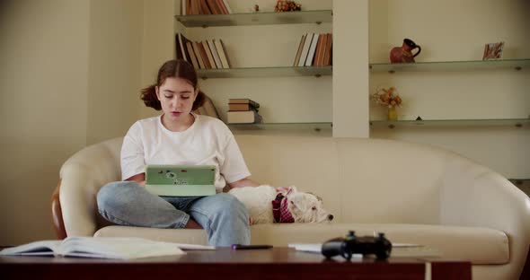 Girl Using Digital Tablet Technology Device in an Online Lesson Talking on Video Via Tablet alt