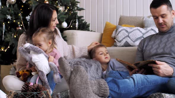 Family with Three Children Is Spending Time Together at Home in Christmas Eve