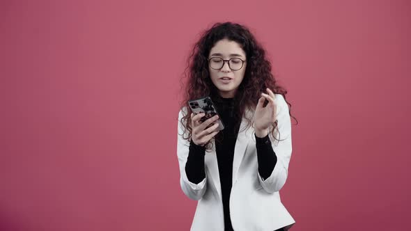 Distracted Young Woman with Curly Hair Dancing While Listening to a Song on the Phone alt