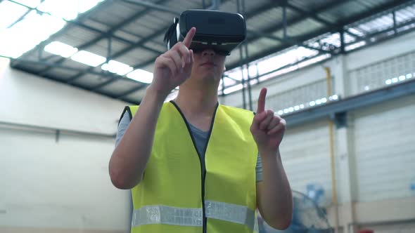 Industrial Factory Worker Wearing VR Goggle Touching in Virtual Reality World Inside Factory alt
