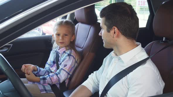 The Young Father Communicates with the Daughter Sitting in the Car