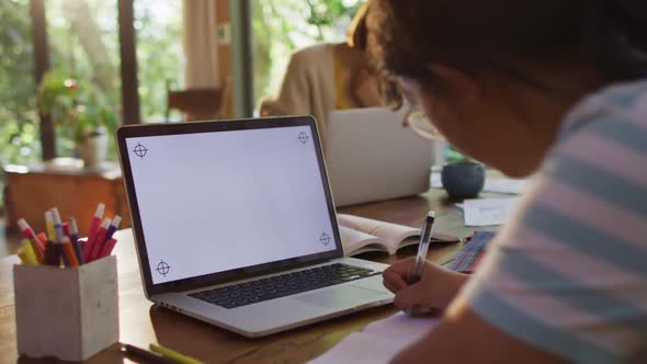 Asian mother and daughter learning and working using laptop with copy space alt