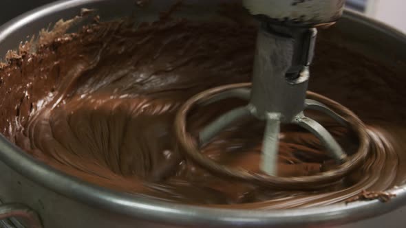 Mixing ingredients for chocolate fudge at candy factory