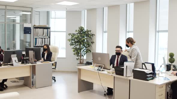 Busy Businesspeople in Face Masks Working in Office alt