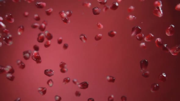 Pomegranate Grains Falling on Red Background alt