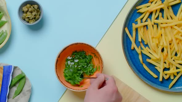Vertical Flat Lay Video Chef Mixes Sauce with Herbs for the French Fries