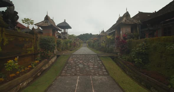Slow Dolly View of Walking Up the Cobblestone Path in a Traditional Penglipuran Village in Bali alt
