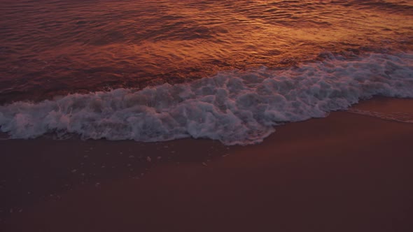 Sea waves on the beach at sunset background
