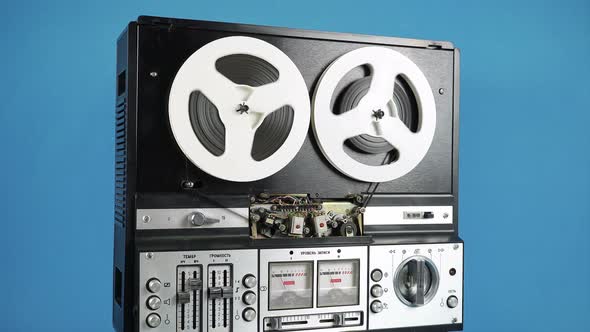 Rotating Old Reel To Reel Tape Recorder On A Blue Background.