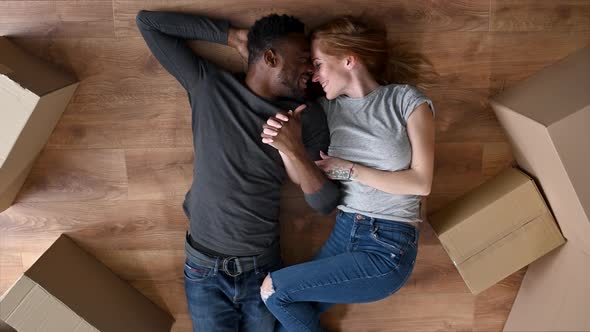 A Interracial Lovely Couple Lays on the Floor alt