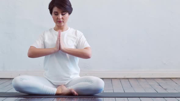 Young and fit woman practicing yoga indoor in the class. alt