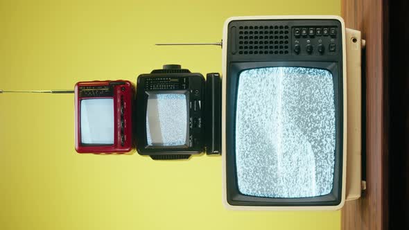 Vertical Video of Old Televisions with Grey Interference Screen on Yellow Background alt